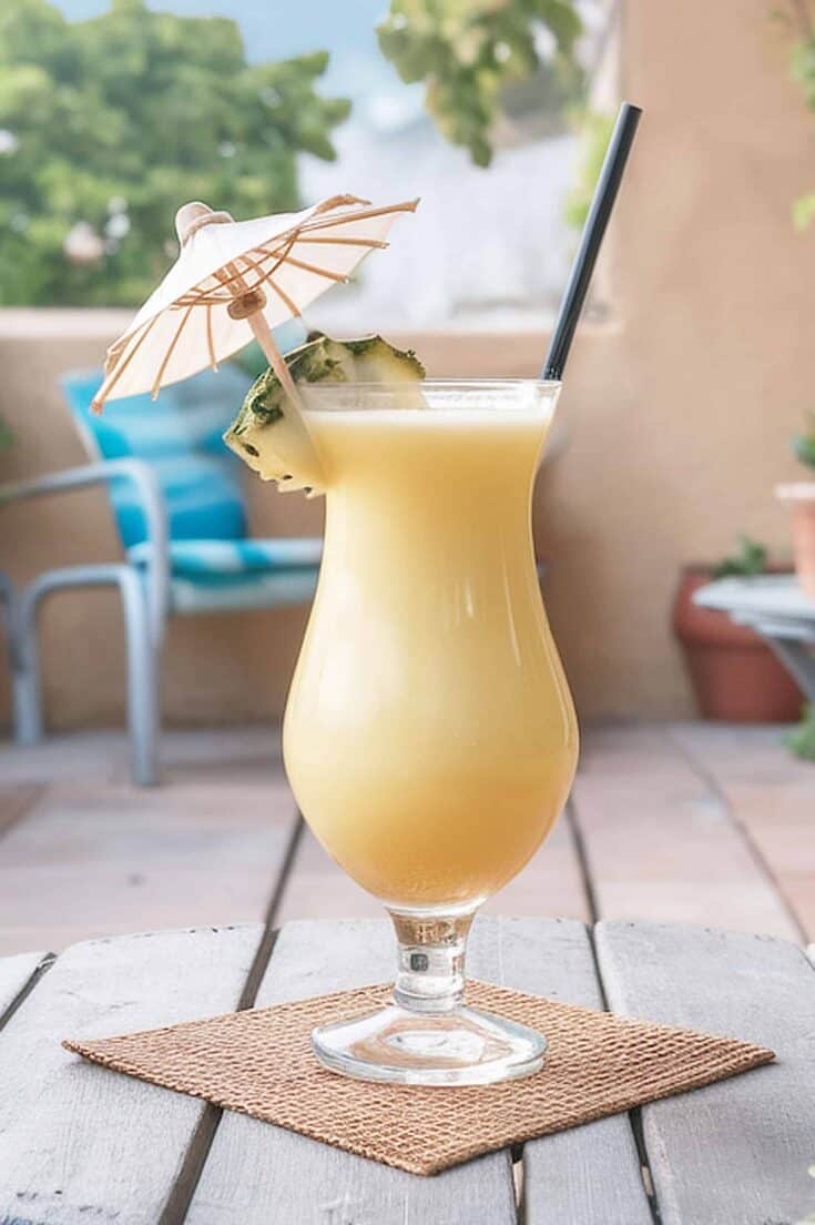 Creamy piña colada in a curved glass with a paper cocktail umbrella
